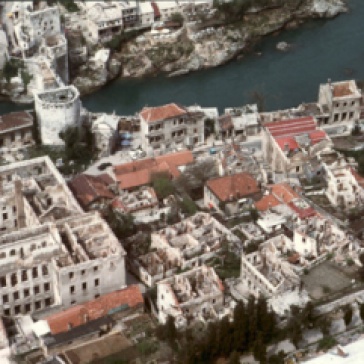 The City of Mostar showing the extensive damage wrought by conflict in the city. The destroyed Old Mostar Bridge is visible in the top left hand corner, the original structure replaced by a temporary pedestrian bridge.